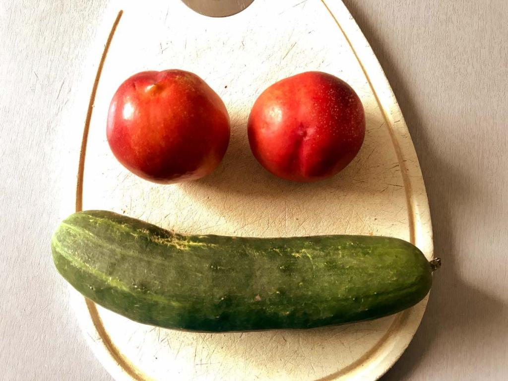 Cutting board with two nuggets and a cucumber